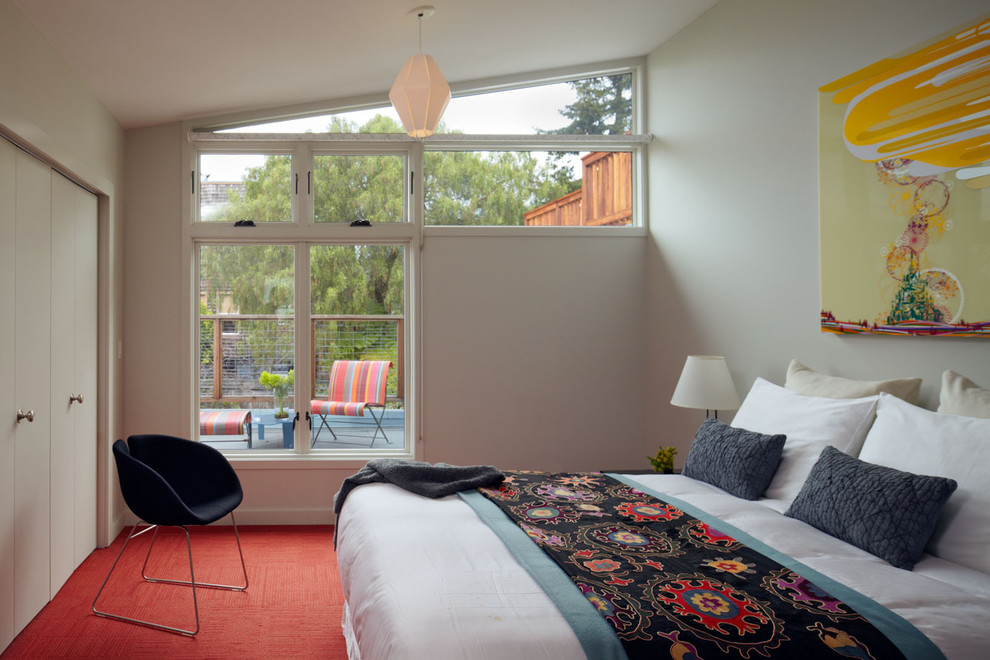 Diseño de dormitorio principal actual de tamaño medio sin chimenea con paredes blancas, moqueta y suelo rojo