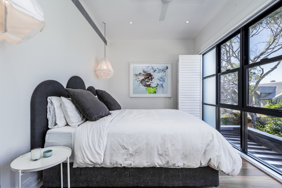 Idee per una camera da letto minimal con pareti bianche, parquet scuro e pavimento marrone