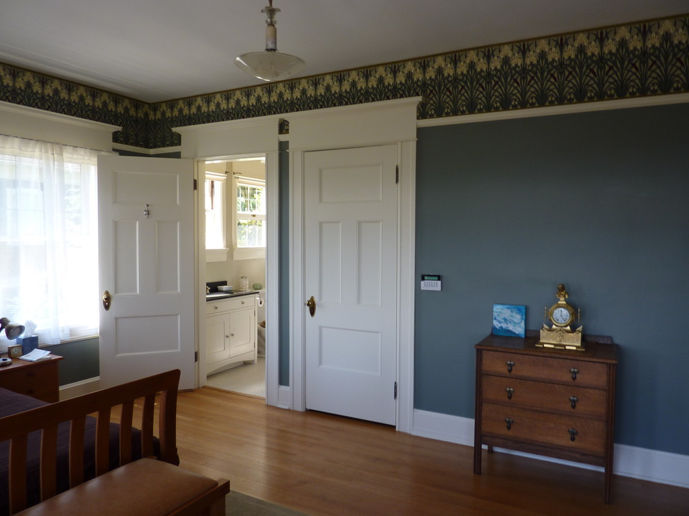 Foto di una camera da letto stile americano con pareti blu e pavimento in legno massello medio