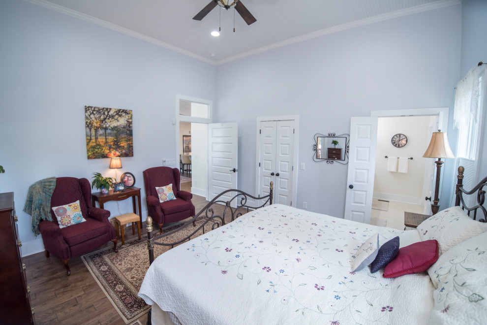 Cette photo montre une chambre chic de taille moyenne avec un mur bleu, parquet foncé, un sol marron et un plafond en bois.