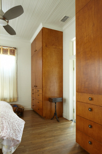 Mittelgroßes Country Hauptschlafzimmer ohne Kamin mit weißer Wandfarbe und braunem Holzboden in Austin