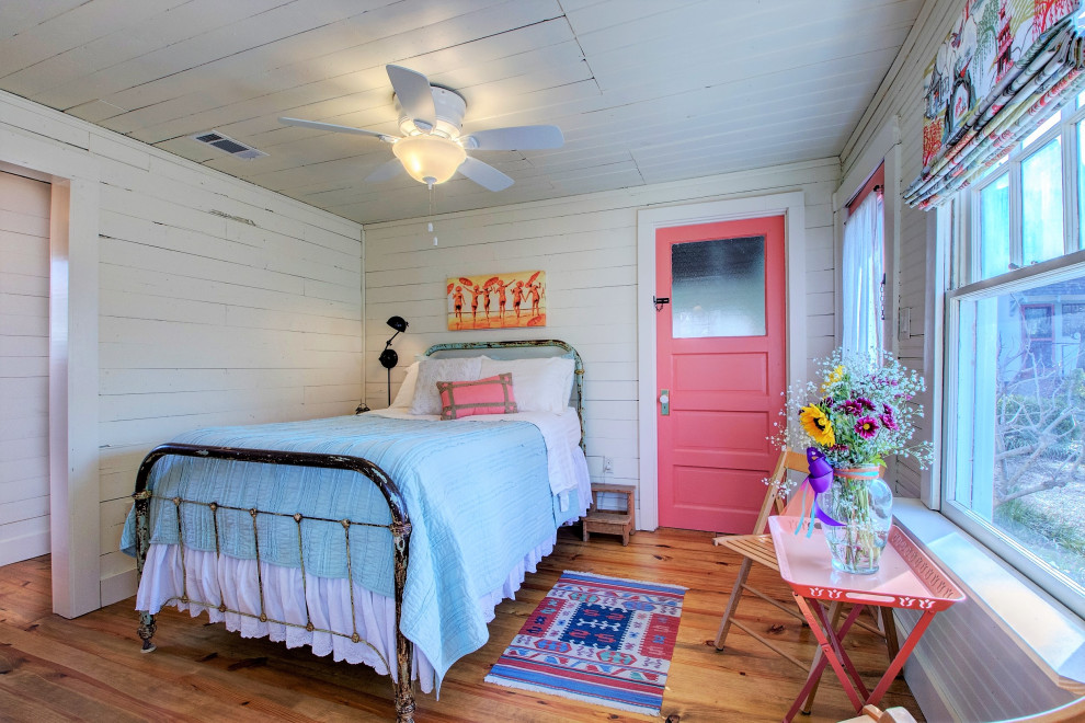 Kleines Shabby-Style Schlafzimmer mit weißer Wandfarbe, braunem Holzboden, braunem Boden, Holzdielendecke und Holzdielenwänden in Little Rock