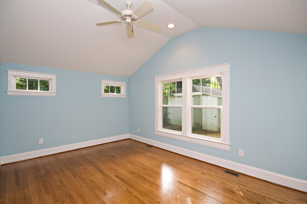Photo of a large contemporary master bedroom in Raleigh with blue walls and light hardwood flooring.