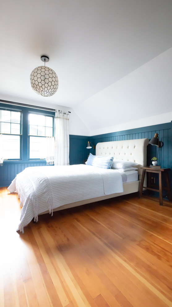 Ejemplo de dormitorio principal tradicional de tamaño medio sin chimenea con paredes azules, suelo de madera en tonos medios y suelo marrón