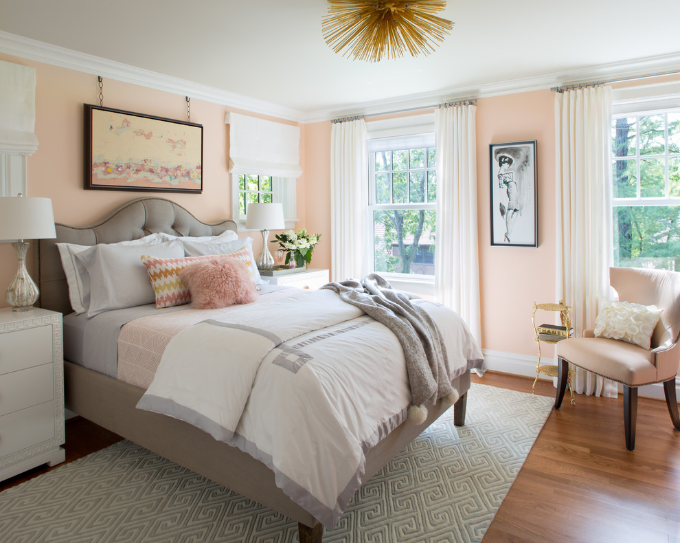 Mid-sized transitional medium tone wood floor bedroom photo in St Louis with pink walls