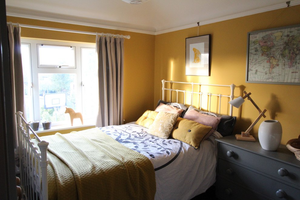 Modelo de habitación de invitados escandinava pequeña con paredes amarillas, suelo de madera oscura, todas las chimeneas y marco de chimenea de baldosas y/o azulejos