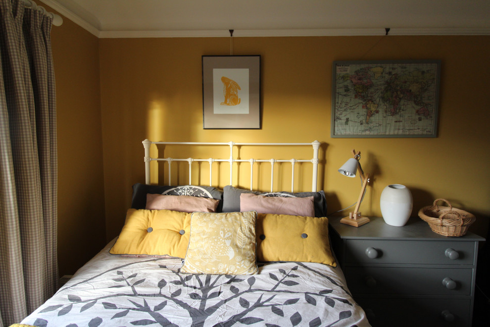 Immagine di una piccola camera degli ospiti nordica con pareti gialle, parquet scuro, camino classico e cornice del camino piastrellata