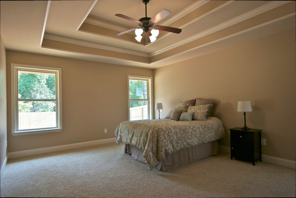 This is an example of a large traditional master bedroom in Austin with beige walls, carpet, no fireplace and grey floors.
