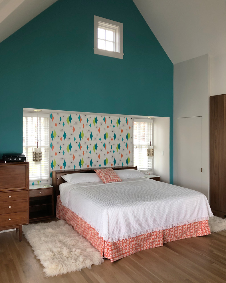 Foto de dormitorio tipo loft retro pequeño con paredes azules, suelo de madera en tonos medios y suelo marrón