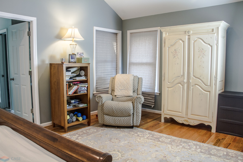 Aménagement d'une chambre parentale classique de taille moyenne avec un mur bleu, parquet clair et un sol orange.