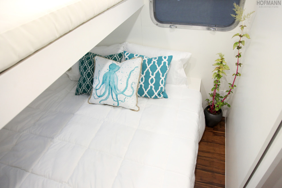 Diseño de dormitorio actual pequeño con paredes blancas y suelo de madera en tonos medios