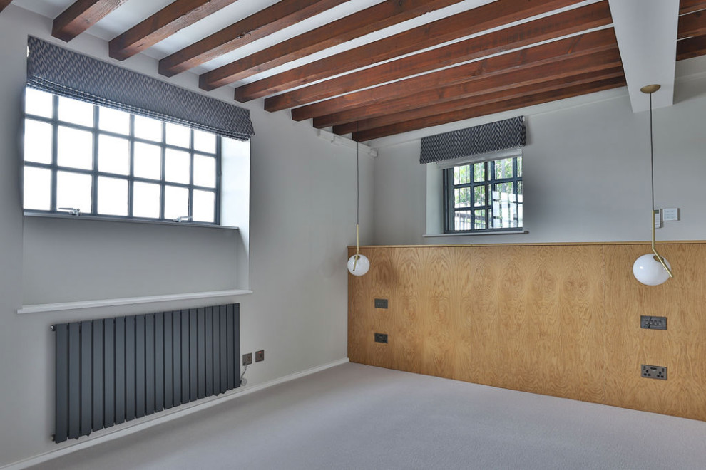 Ejemplo de dormitorio principal moderno de tamaño medio con paredes grises, moqueta, suelo gris y vigas vistas