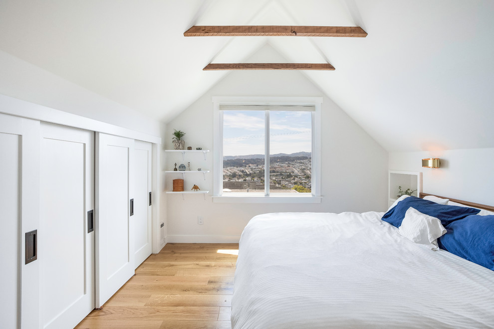 Example of a mid-sized danish master medium tone wood floor and brown floor bedroom design in San Francisco with white walls