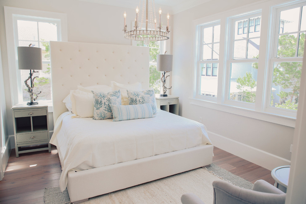 Bedroom - coastal medium tone wood floor and brown floor bedroom idea in Miami with white walls