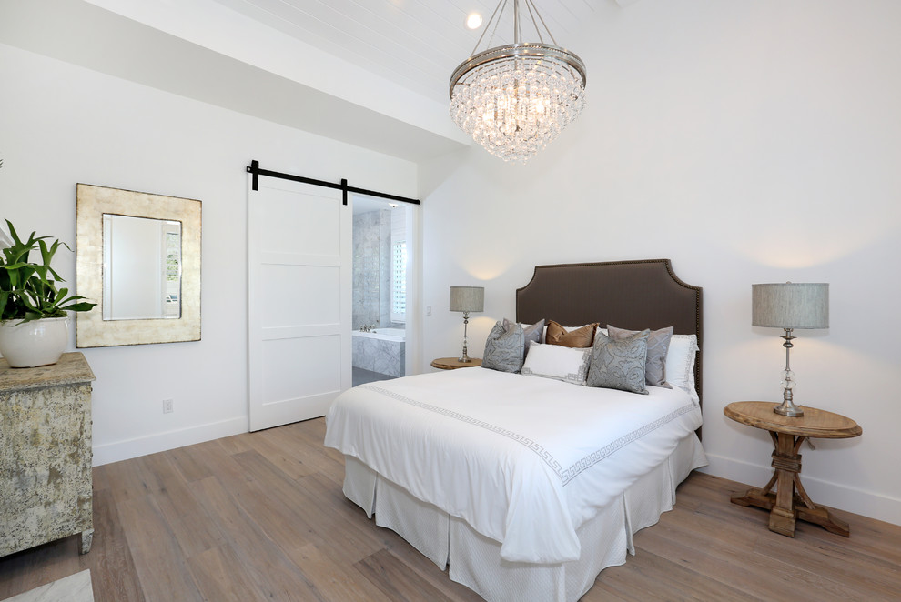 На фото: гостевая спальня (комната для гостей) с белыми стенами и светлым паркетным полом с