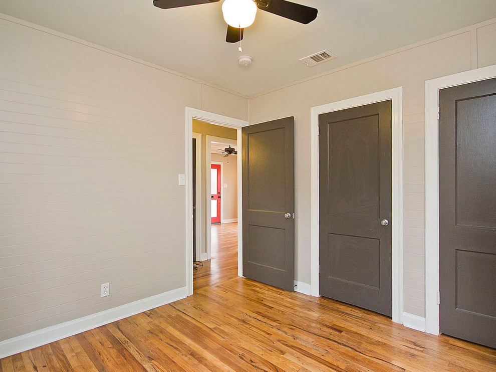 Foto de dormitorio tipo loft de estilo americano de tamaño medio con paredes beige y suelo de madera clara