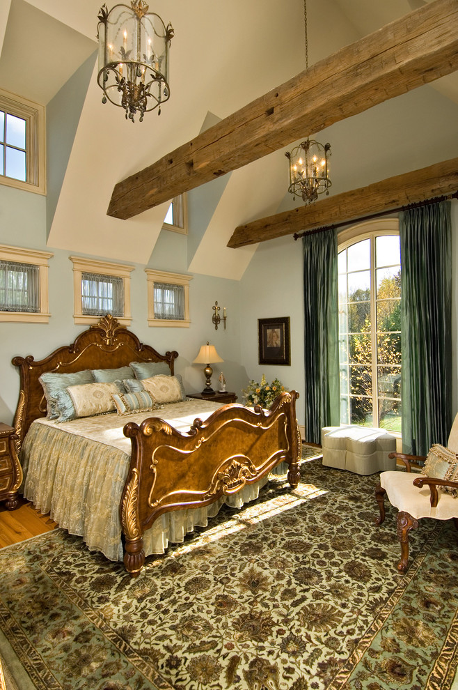 Foto di una camera da letto tradizionale con pareti blu e pavimento in legno massello medio