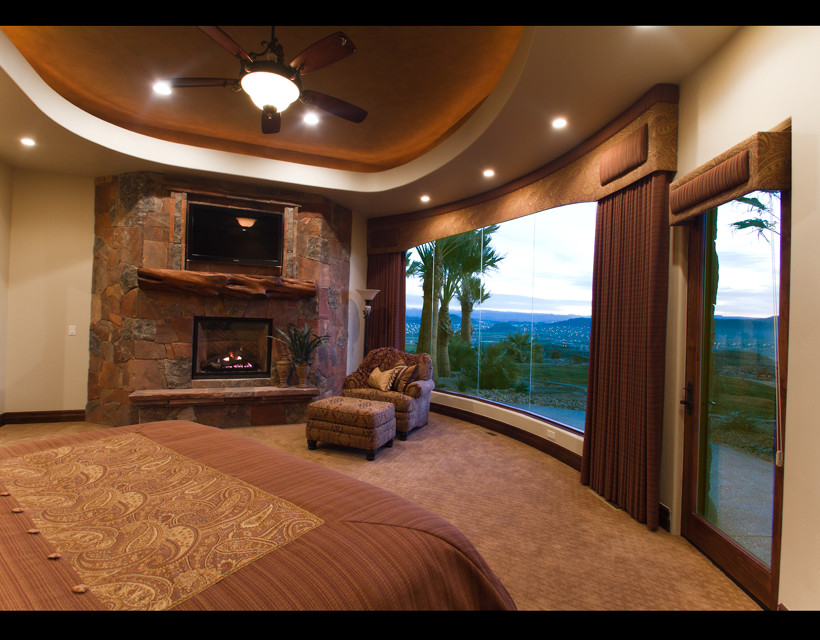 На фото: большая хозяйская спальня в классическом стиле с бежевыми стенами, ковровым покрытием, стандартным камином и фасадом камина из камня с