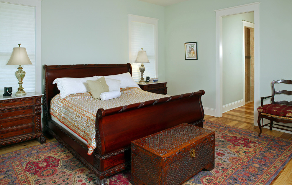 Ejemplo de dormitorio tradicional con paredes verdes y suelo de madera en tonos medios