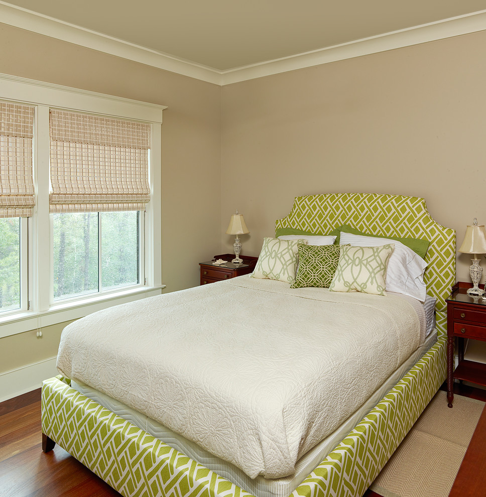 Modelo de habitación de invitados tradicional con paredes beige y suelo de madera en tonos medios