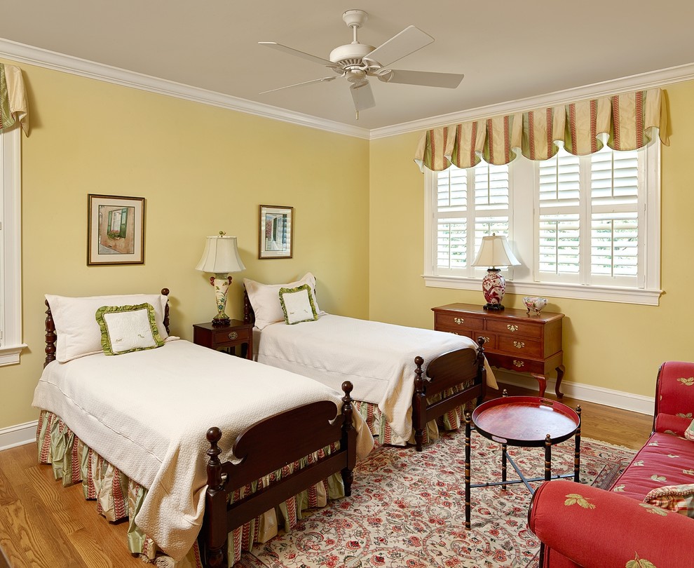 Photo of a traditional guest bedroom in Charleston with yellow walls and light hardwood flooring.