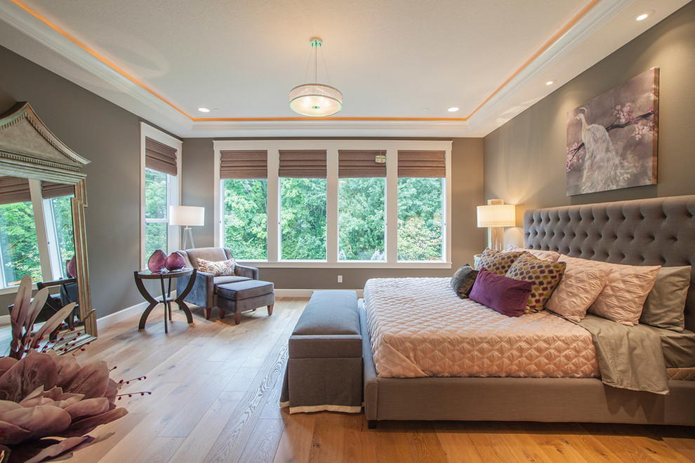 Modelo de dormitorio principal clásico renovado con paredes grises y suelo de madera en tonos medios