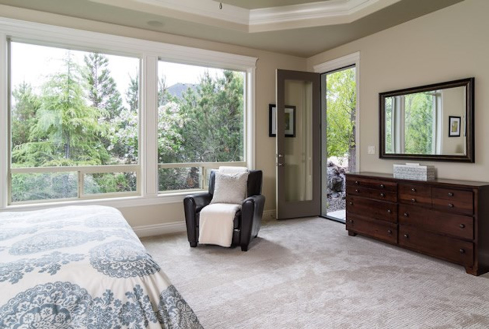 Design ideas for a large contemporary master bedroom in Boise with beige walls and carpet.