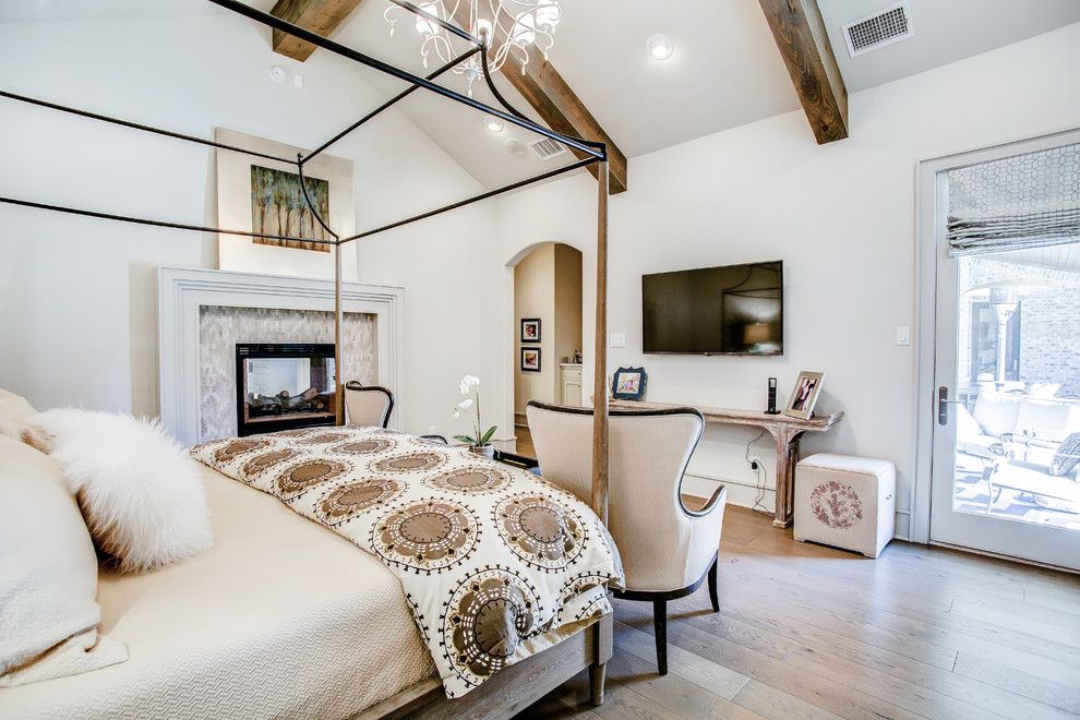 Großes Klassisches Hauptschlafzimmer mit weißer Wandfarbe, braunem Holzboden, braunem Boden, Kamin und gefliester Kaminumrandung in Austin