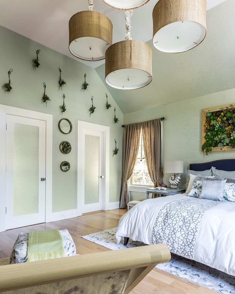 Foto de habitación de invitados tradicional de tamaño medio sin chimenea con paredes verdes y suelo de madera clara
