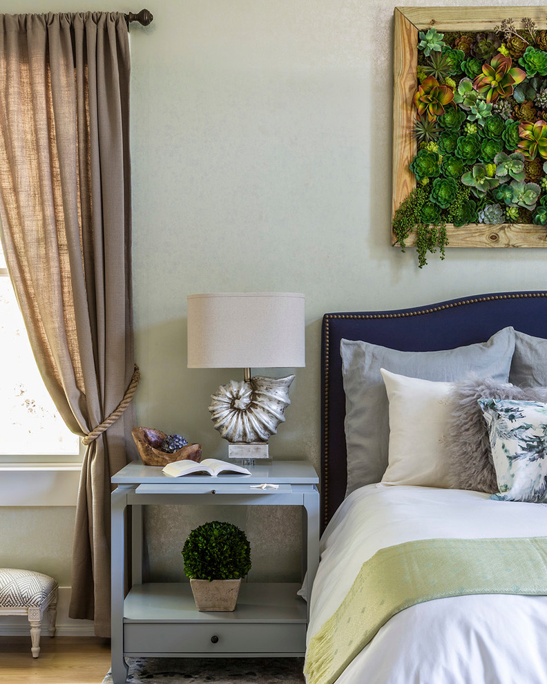 Imagen de habitación de invitados tradicional de tamaño medio sin chimenea con paredes verdes y suelo de madera clara