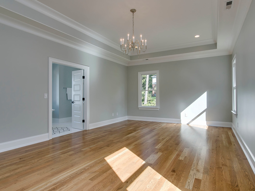 Großes Klassisches Hauptschlafzimmer ohne Kamin mit grauer Wandfarbe und braunem Holzboden in Raleigh