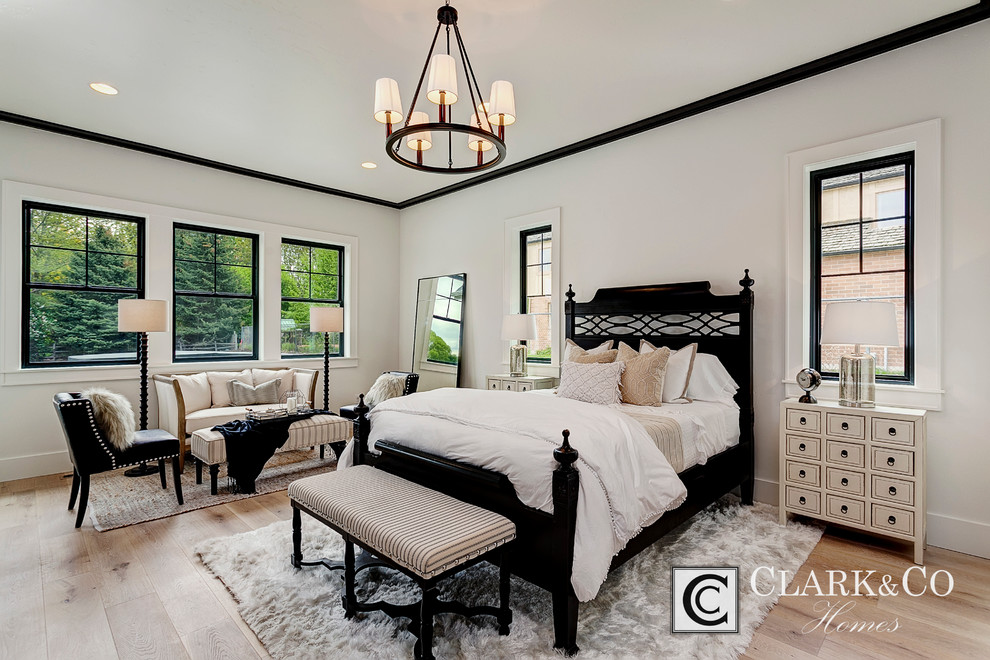 Großes Country Hauptschlafzimmer ohne Kamin mit weißer Wandfarbe und hellem Holzboden in Boise