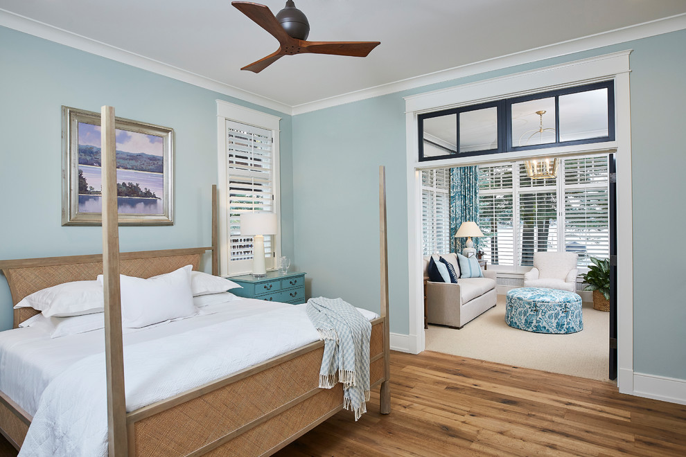 Ejemplo de dormitorio principal marinero grande sin chimenea con paredes azules y suelo de madera en tonos medios