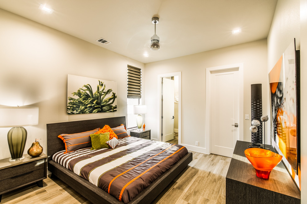 Esempio di una camera degli ospiti minimalista di medie dimensioni con pareti beige, parquet chiaro, nessun camino e pavimento marrone