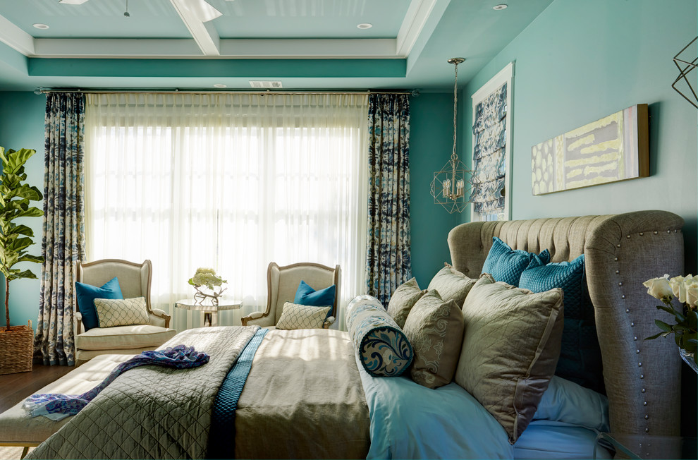Cette image montre une grande chambre parentale traditionnelle avec un mur bleu, parquet foncé, aucune cheminée et un sol marron.