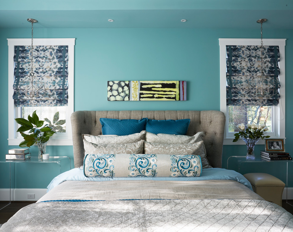 This is an example of a large classic master bedroom in Houston with blue walls, dark hardwood flooring, no fireplace and brown floors.