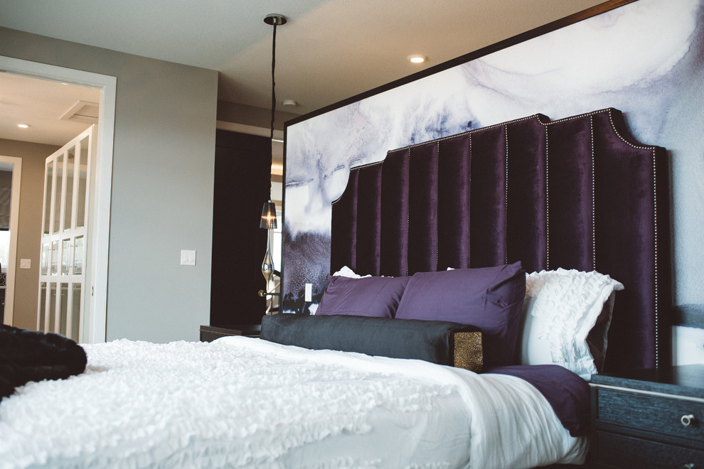 Large modern bedroom in Edmonton with beige walls, medium hardwood flooring, no fireplace and brown floors.