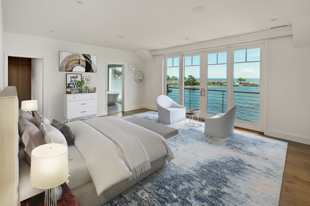 Esempio di una camera da letto costiera con pareti bianche, pavimento in legno massello medio e pavimento marrone