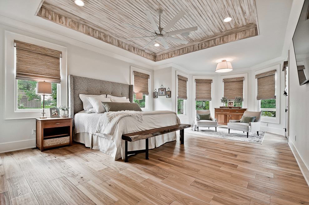 Landhaus Schlafzimmer mit grauer Wandfarbe, braunem Holzboden und braunem Boden in Sonstige