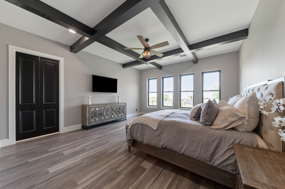 Mittelgroßes Landhaus Hauptschlafzimmer mit grauer Wandfarbe, braunem Holzboden, braunem Boden und freigelegten Dachbalken in Dallas