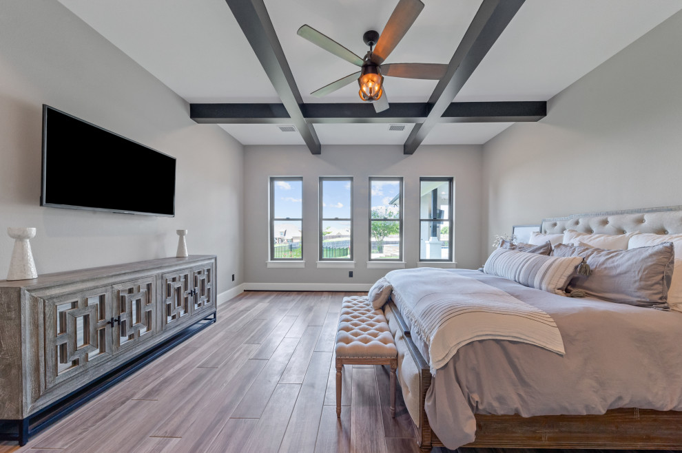 На фото: хозяйская спальня среднего размера в стиле кантри с серыми стенами, паркетным полом среднего тона, коричневым полом и балками на потолке