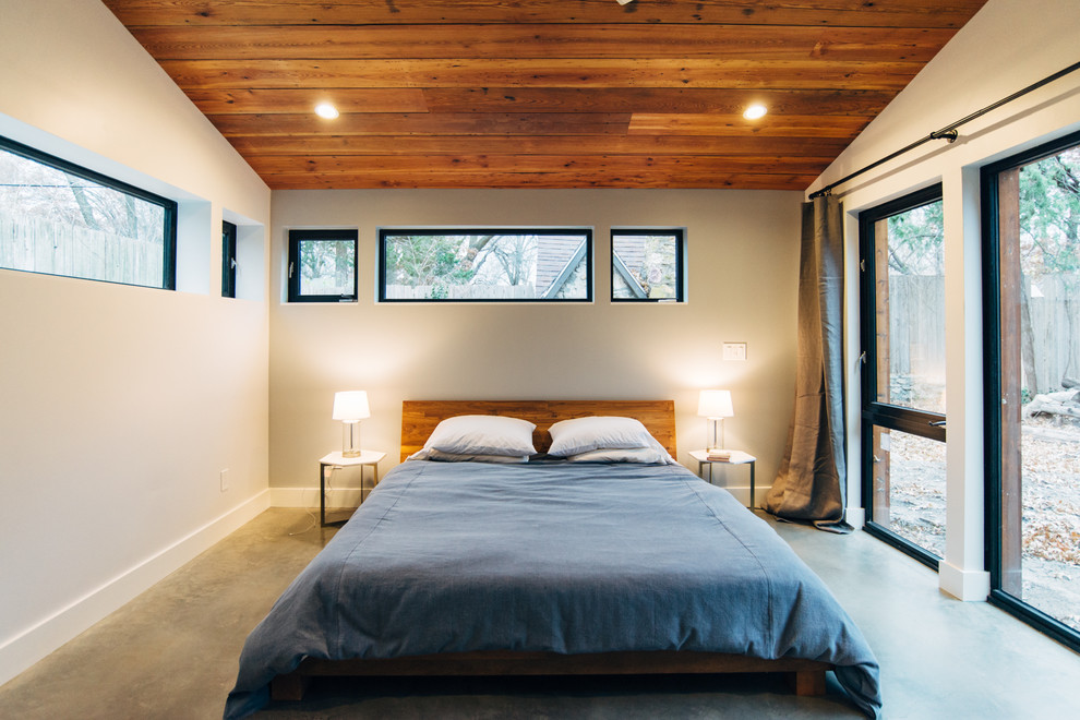 Стильный дизайн: спальня в современном стиле с разноцветными стенами, бетонным полом и серым полом - последний тренд