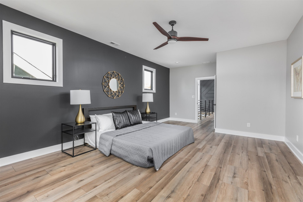 Idée de décoration pour une chambre parentale minimaliste de taille moyenne avec un mur gris, parquet clair et un sol marron.