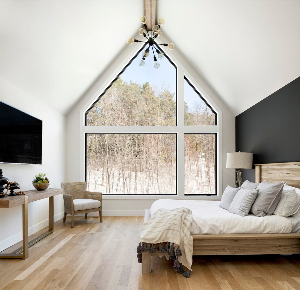 Cette image montre une chambre d'amis nordique avec un mur blanc, parquet clair, aucune cheminée et un sol beige.