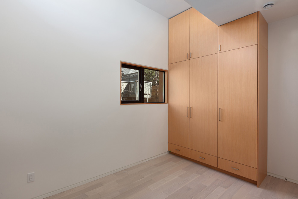 Foto de dormitorio principal con paredes blancas y suelo de madera clara