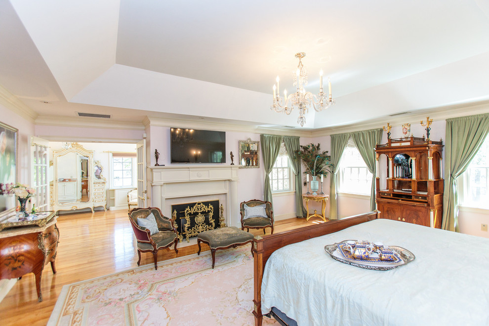 ボストンにある巨大なトラディショナルスタイルのおしゃれな主寝室 (白い壁、無垢フローリング、標準型暖炉、木材の暖炉まわり、マルチカラーの床)