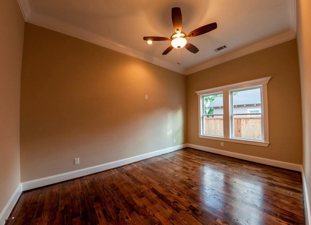 Cette photo montre une chambre d'amis craftsman de taille moyenne avec un mur beige et un sol en bois brun.