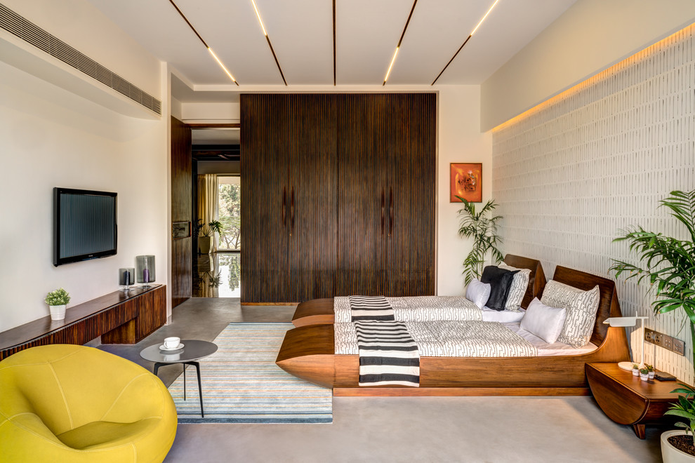 Inspiration for a world-inspired master bedroom in Pune with white walls, concrete flooring and grey floors.