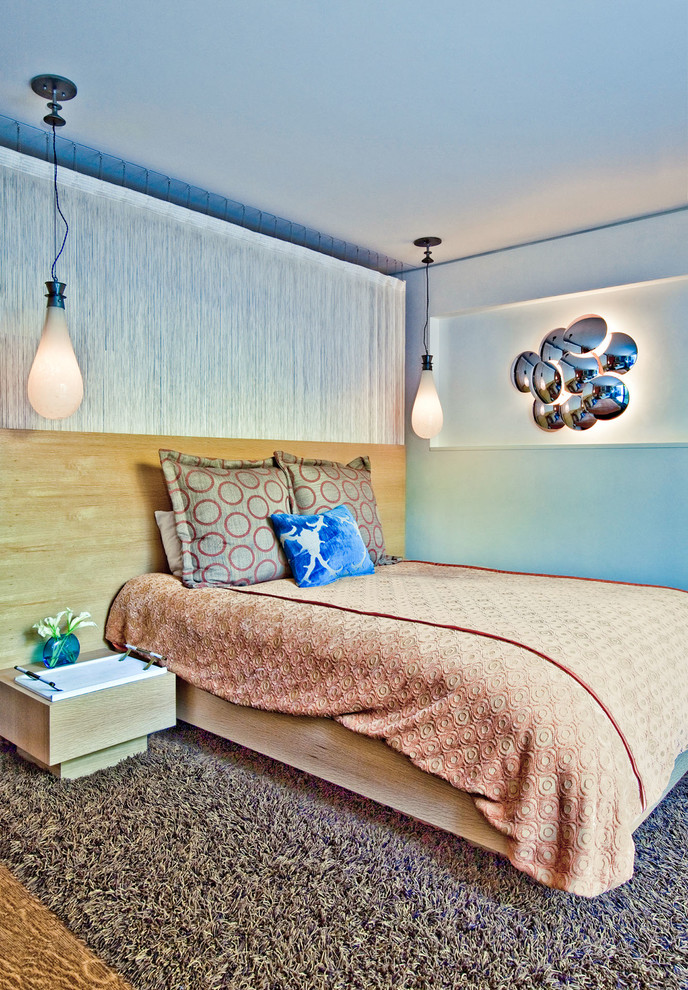 Idées déco pour une chambre d'amis contemporaine de taille moyenne avec un mur bleu et un sol en bois brun.