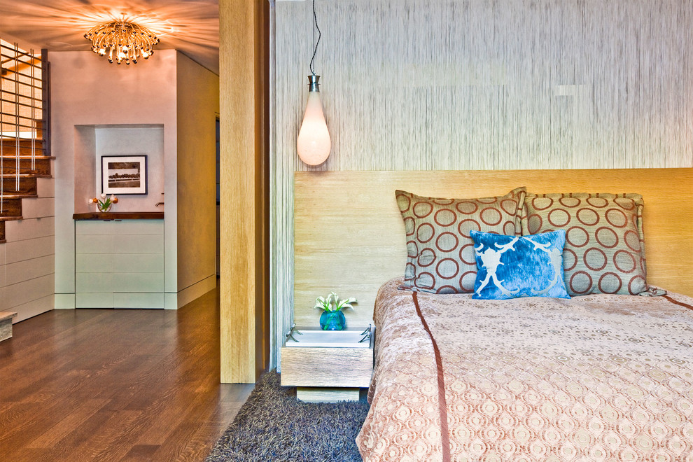 Exemple d'une chambre d'amis tendance de taille moyenne avec un mur bleu et un sol en bois brun.
